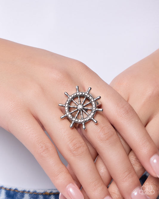 Silver steering wheel ring on a hand against a white background