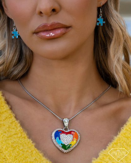 Close-up of multicolor puzzle heart pendant with white rhinestones