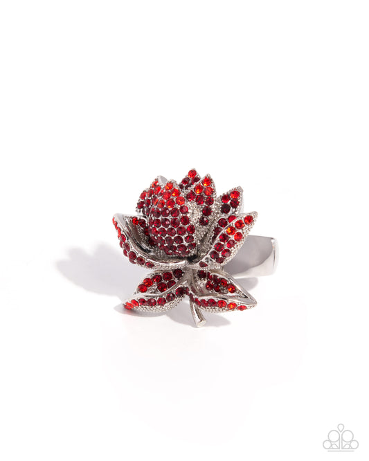 Silver ring with red gemstones on a white background