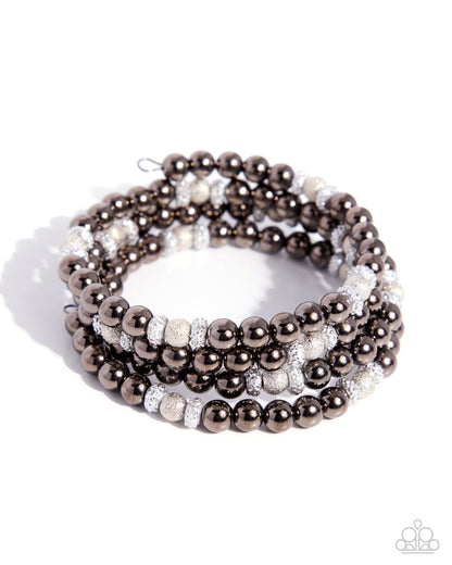 Stack of brown and white beaded bracelets on a white background
