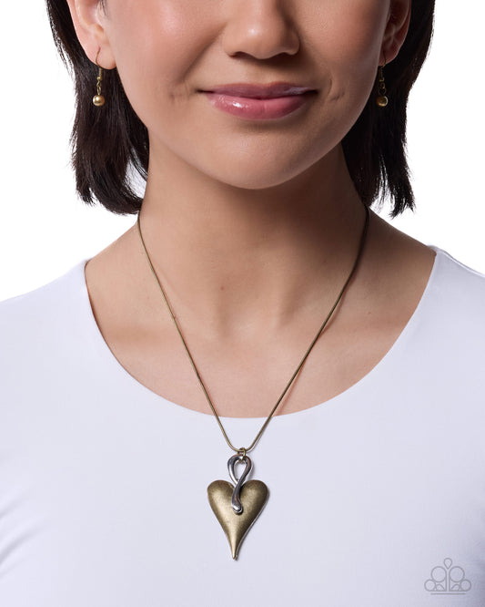 Woman wearing a gold heart-shaped pendant necklace on a white background