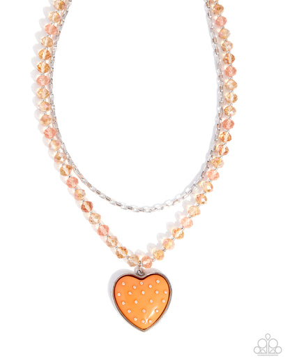 Necklace with heart-shaped orange pendant on a white background