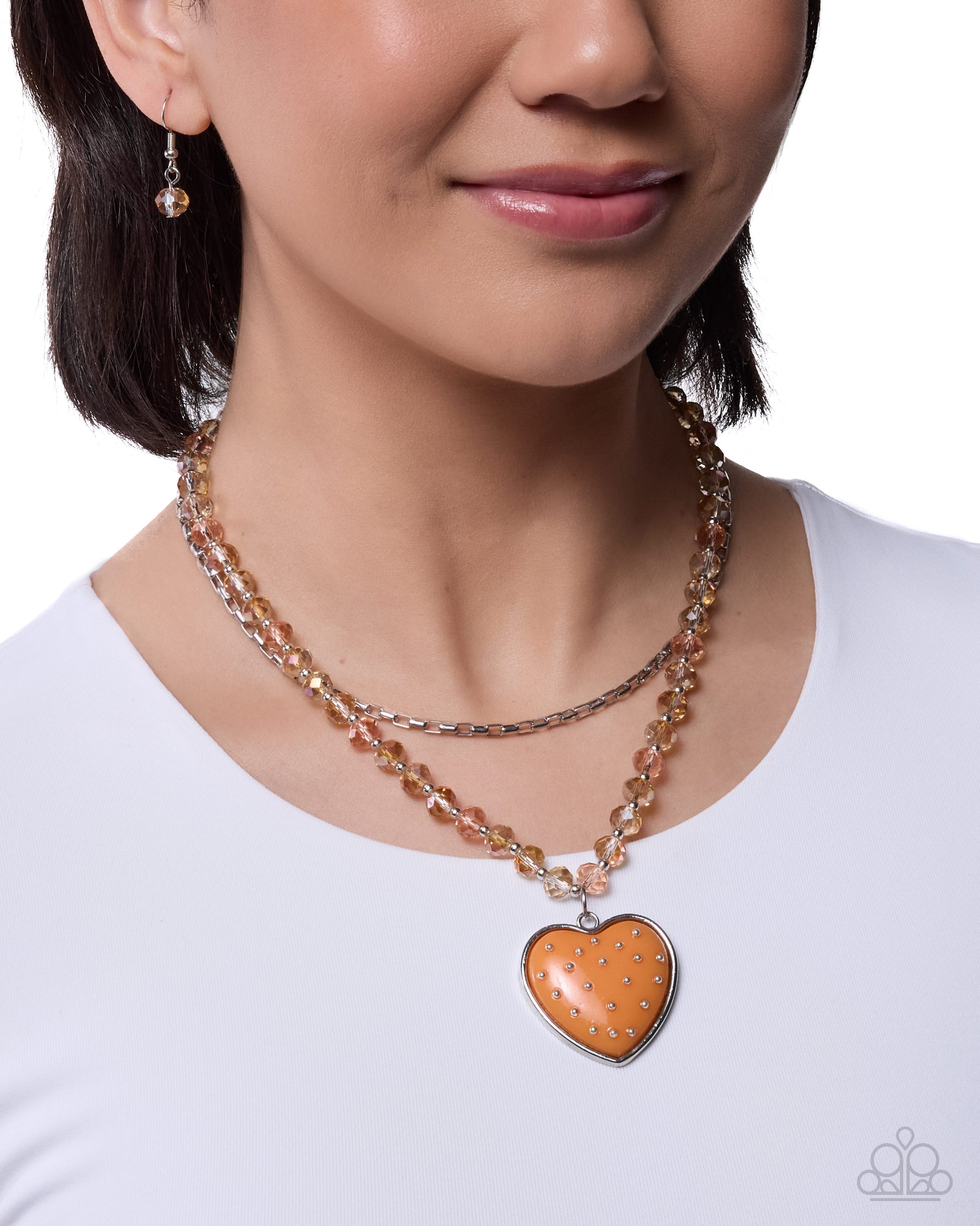 Woman wearing a necklace with a heart-shaped pendant on a white background