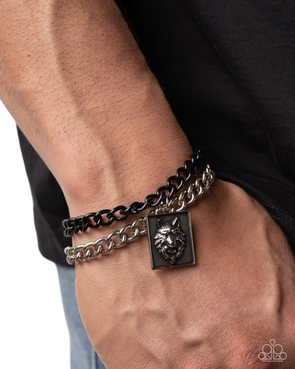 Bracelet with lion head charm on a wrist against a black background
