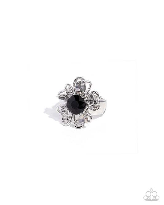 Silver ring with a black gemstone on a white background