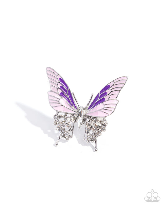A butterfly-shaped brooch with light pink and purple enamel wings, set in silver with clear rhinestones on a white background.