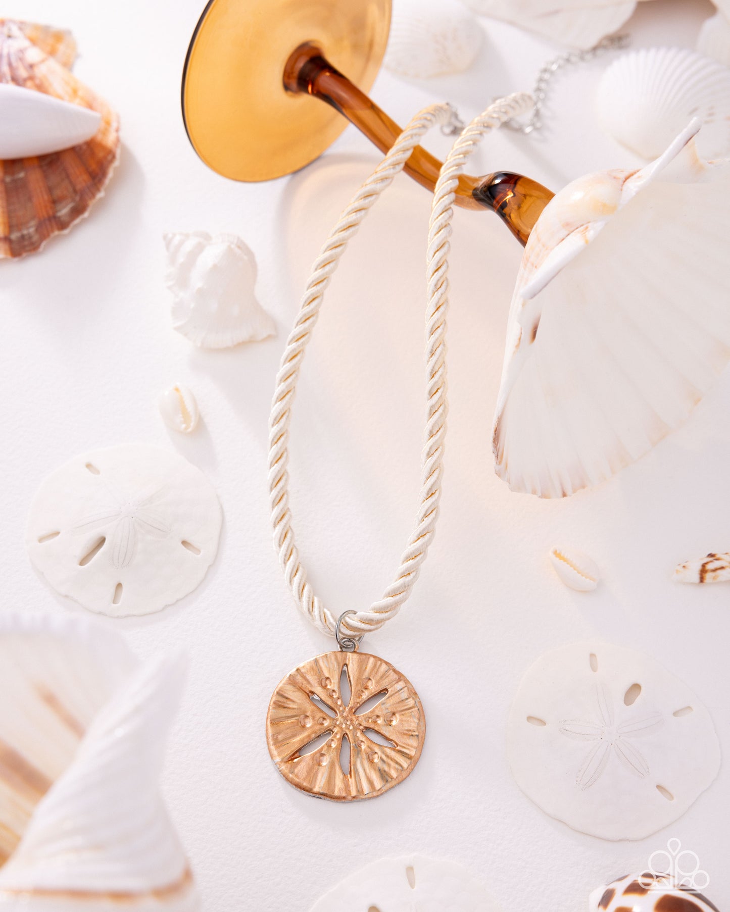 Necklace with a gold pendant on a white background with seashells