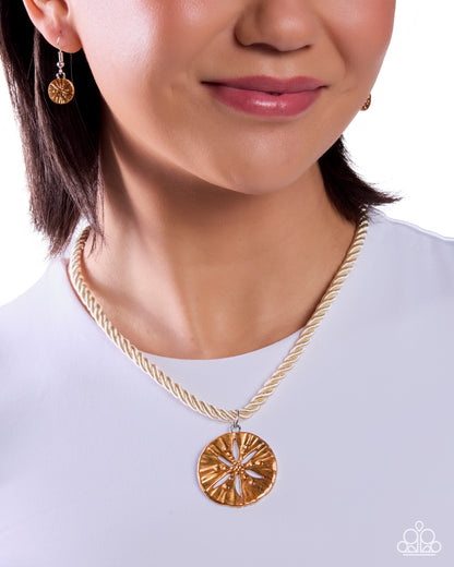 Close-up of a person wearing a gold necklace with a pendant on a white background