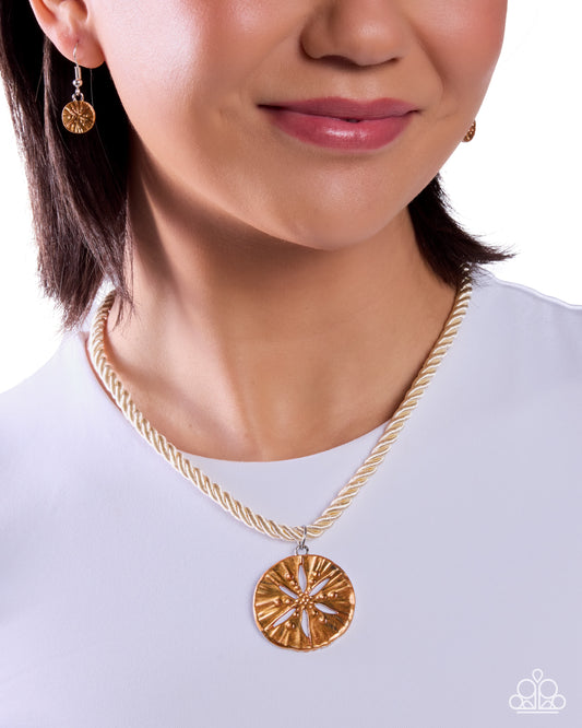 Close-up of a person wearing a gold necklace with a pendant on a white background