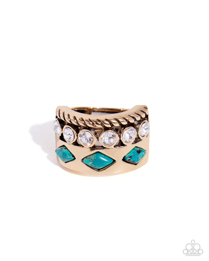 A gold-toned wide band ring featuring a twisted rope texture, clear round crystals, and turquoise-colored diamond-shaped stones, shown on a white background.