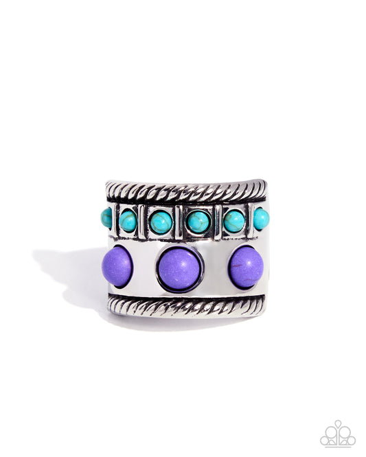 A wide silver-toned band ring featuring a top row of small turquoise-blue stones and a lower row of larger purple oval stones, set against a plain white background.