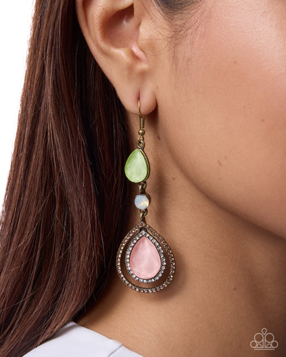 Close-up of an earring with a green and pink teardrop design on a person's ear.