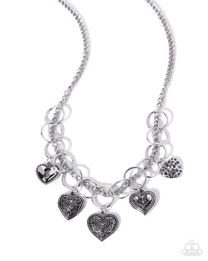 Silver necklace with heart-shaped charms on a white background