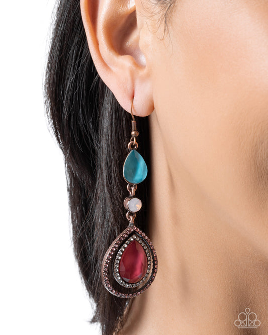 Close-up of an earring with a blue teardrop and red pendant on a white background