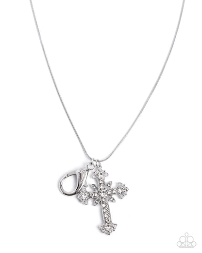A silver cross pendant necklace adorned with clear rhinestones, shown on a delicate silver chain against a white background. A small silver clasp is attached to the cross.