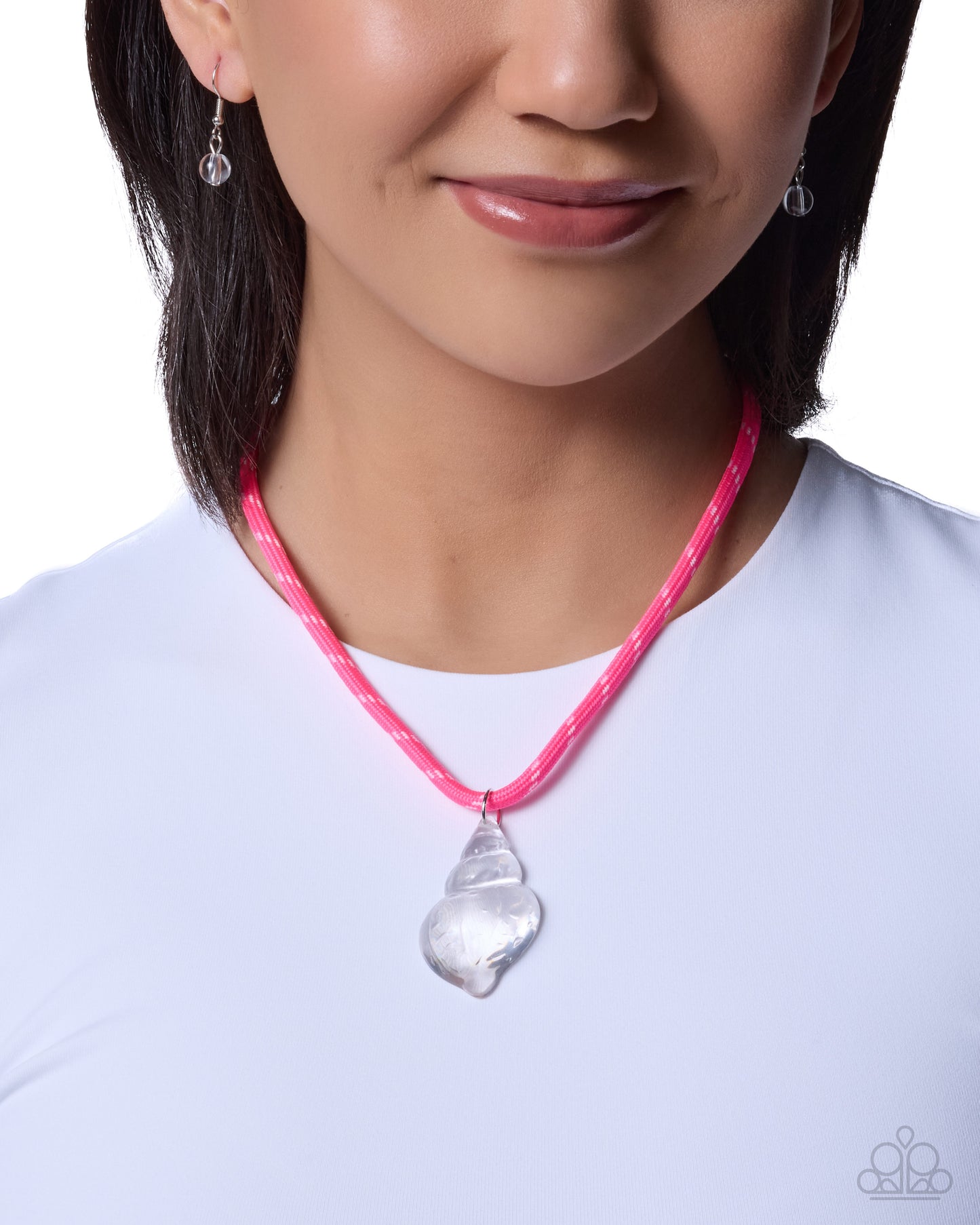 Person wearing a pink necklace with a silver pendant on a white background
