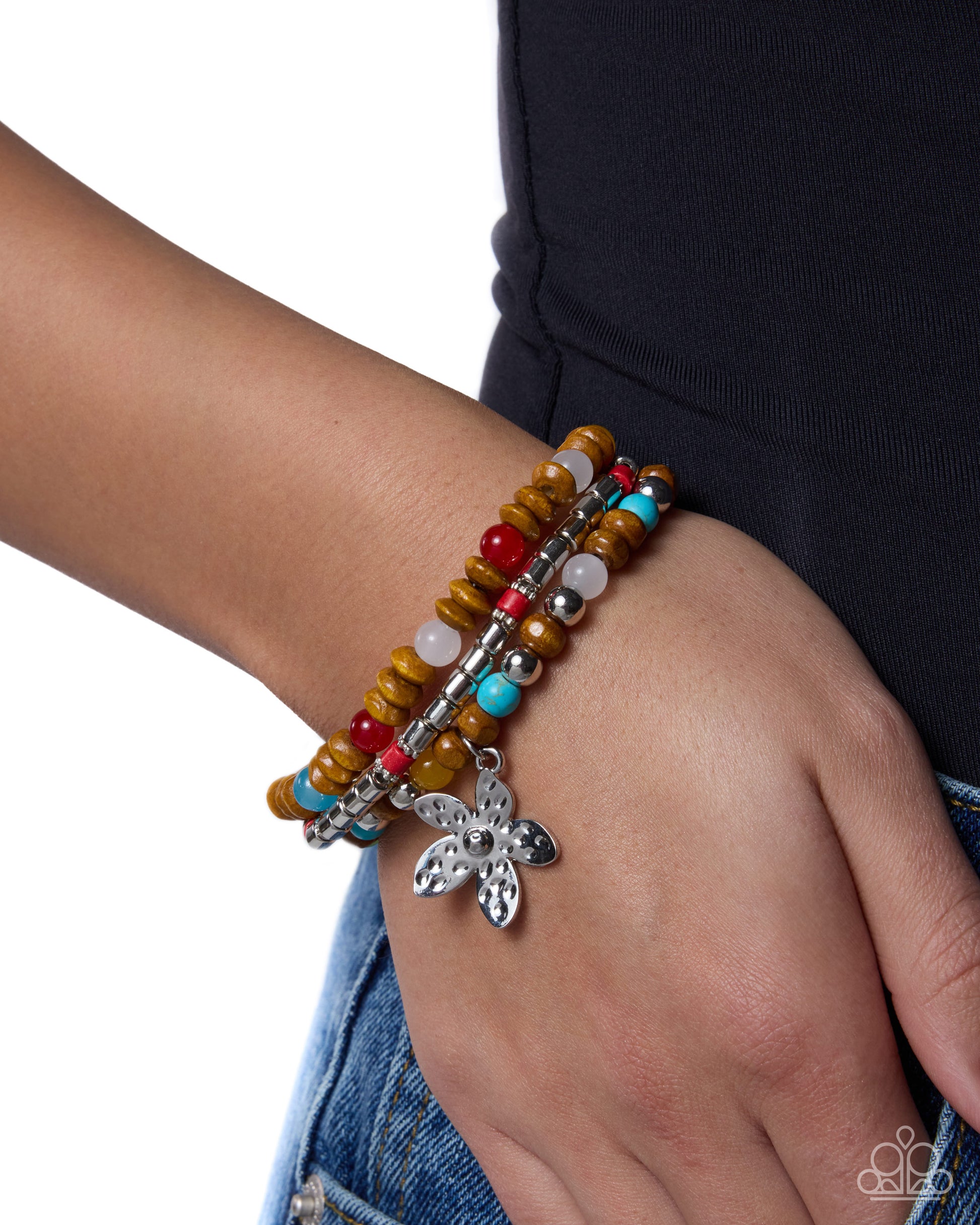 Multicolored beaded bracelet with a silver butterfly charm on a wrist against a white background