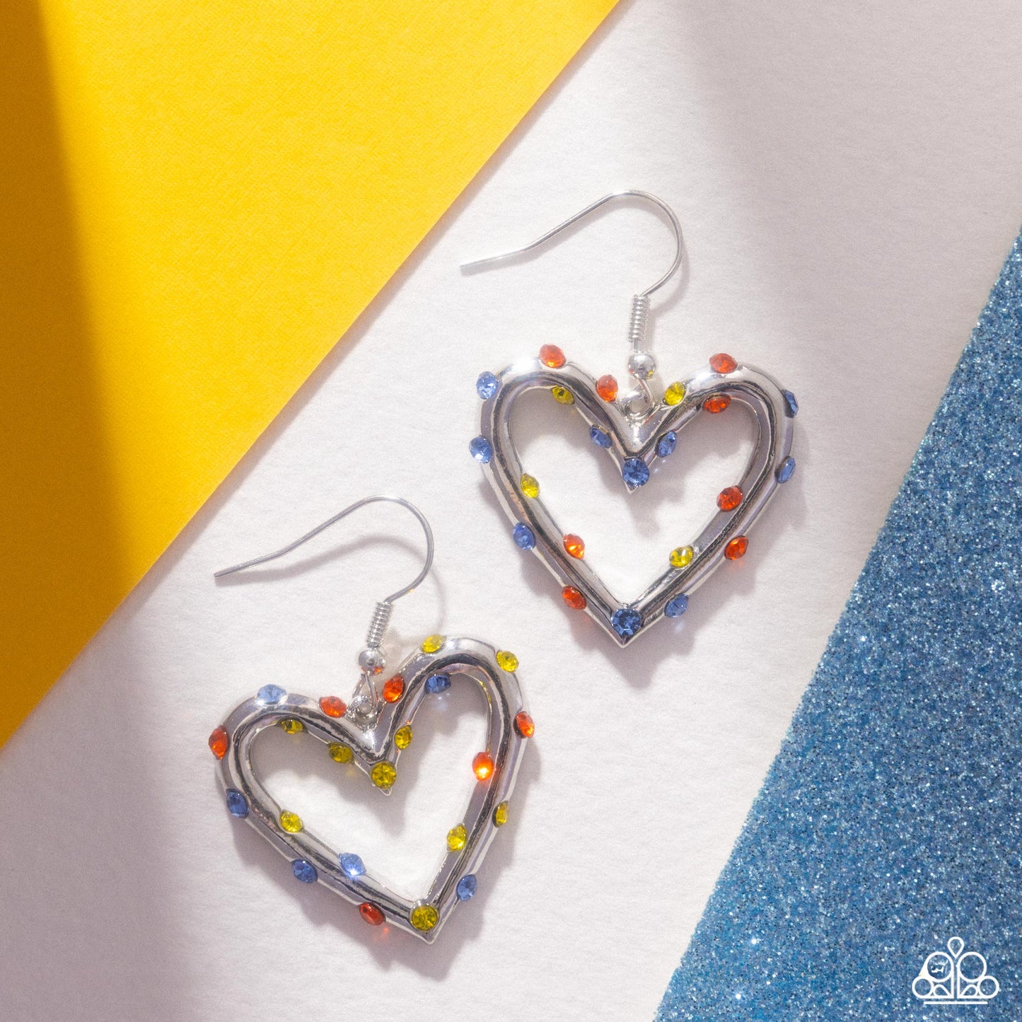 Heart-shaped earrings with colorful beads on a yellow and white background
