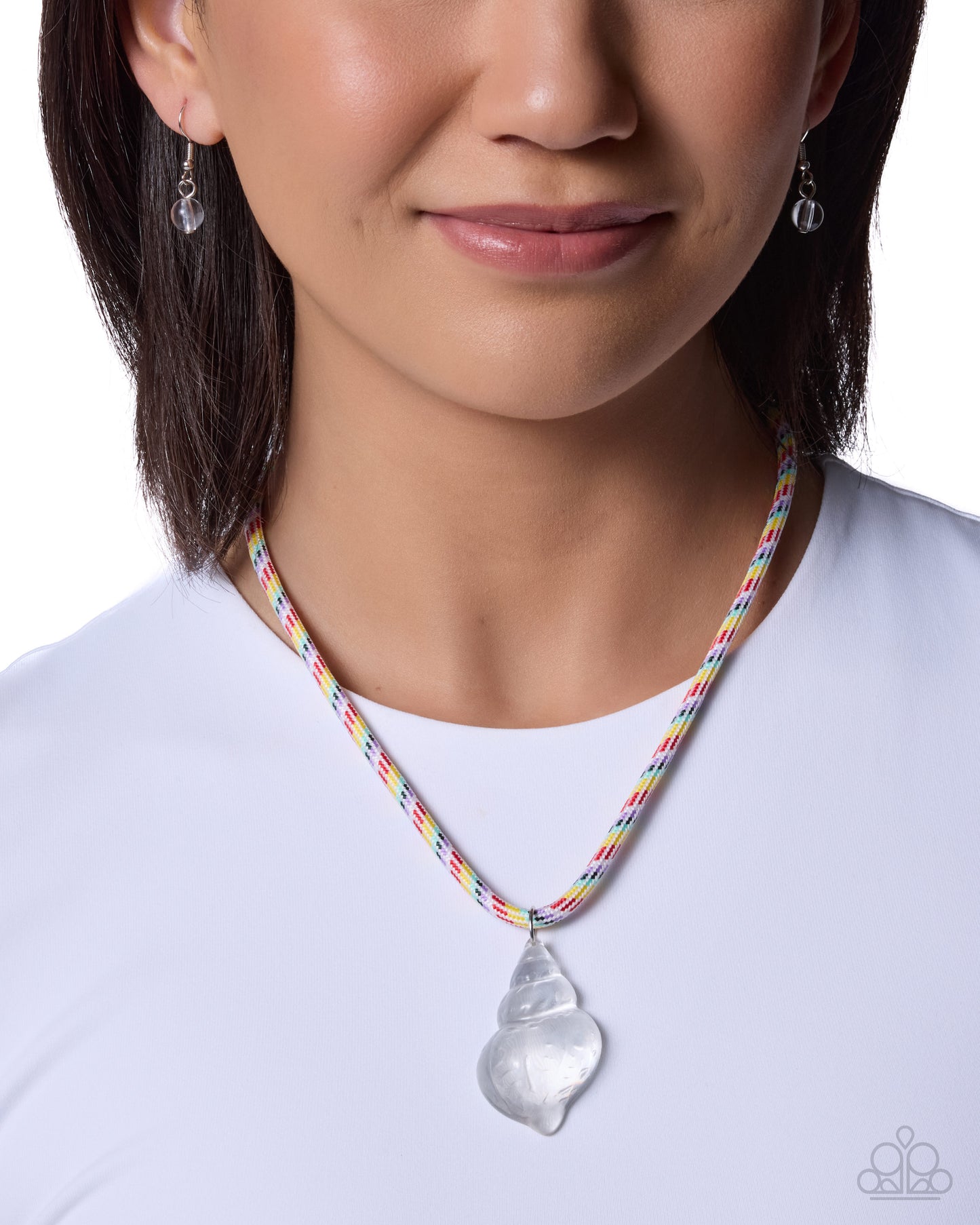 Person wearing a colorful necklace with a clear pendant on a white background