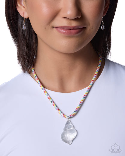 Person wearing a colorful necklace with a clear pendant on a white background