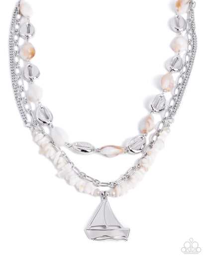 Multi-layered necklace with pearls and silver accents on a white background