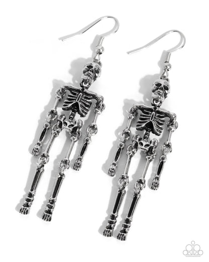 A pair of dangling skeleton earrings in polished silver-tone metal, shown on a clean white background with soft drop shadows. The earrings feature detailed articulated skeleton figures hanging from fishhook wires.