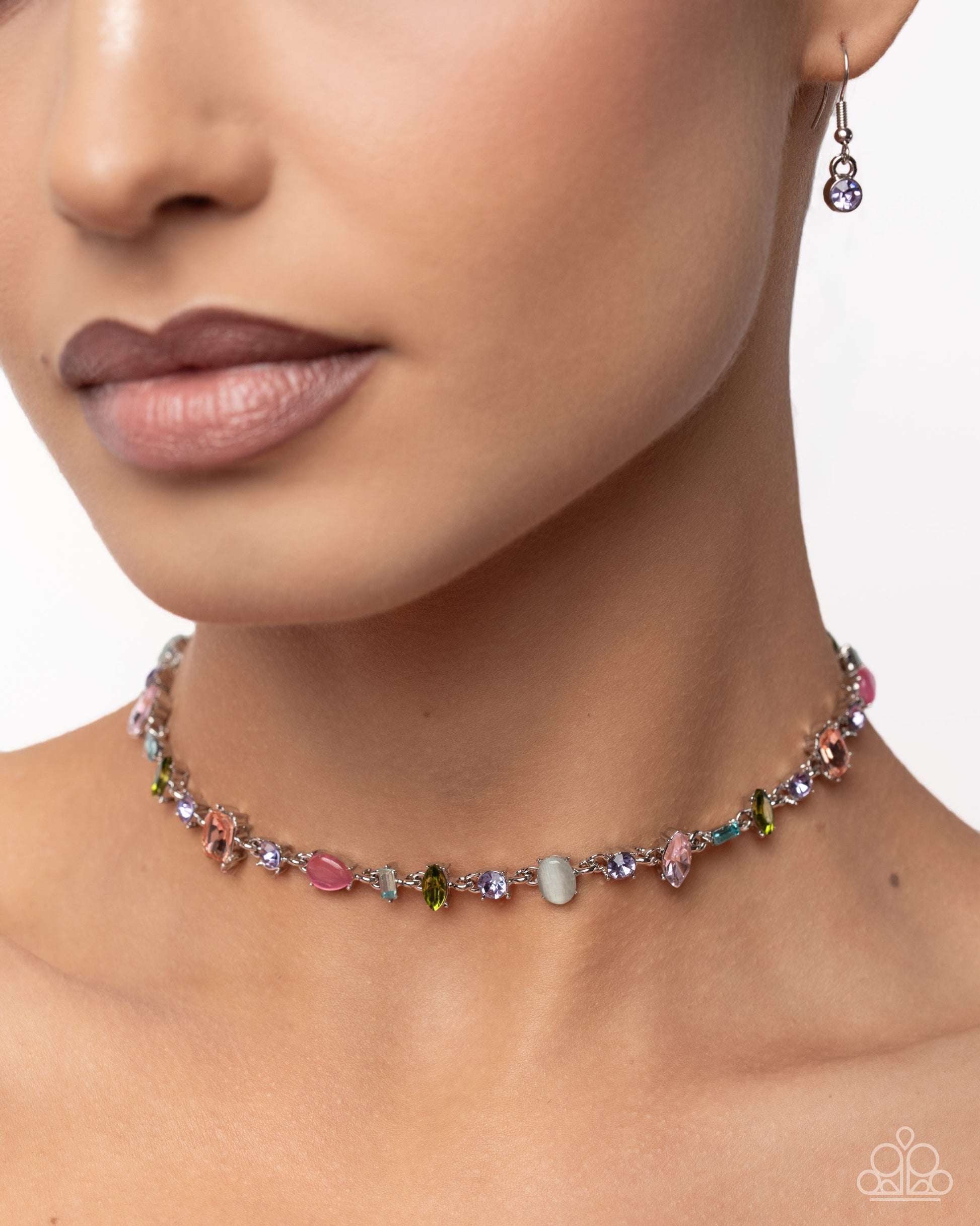 Close-up of a woman wearing a colorful beaded necklace and earrings on a neutral background