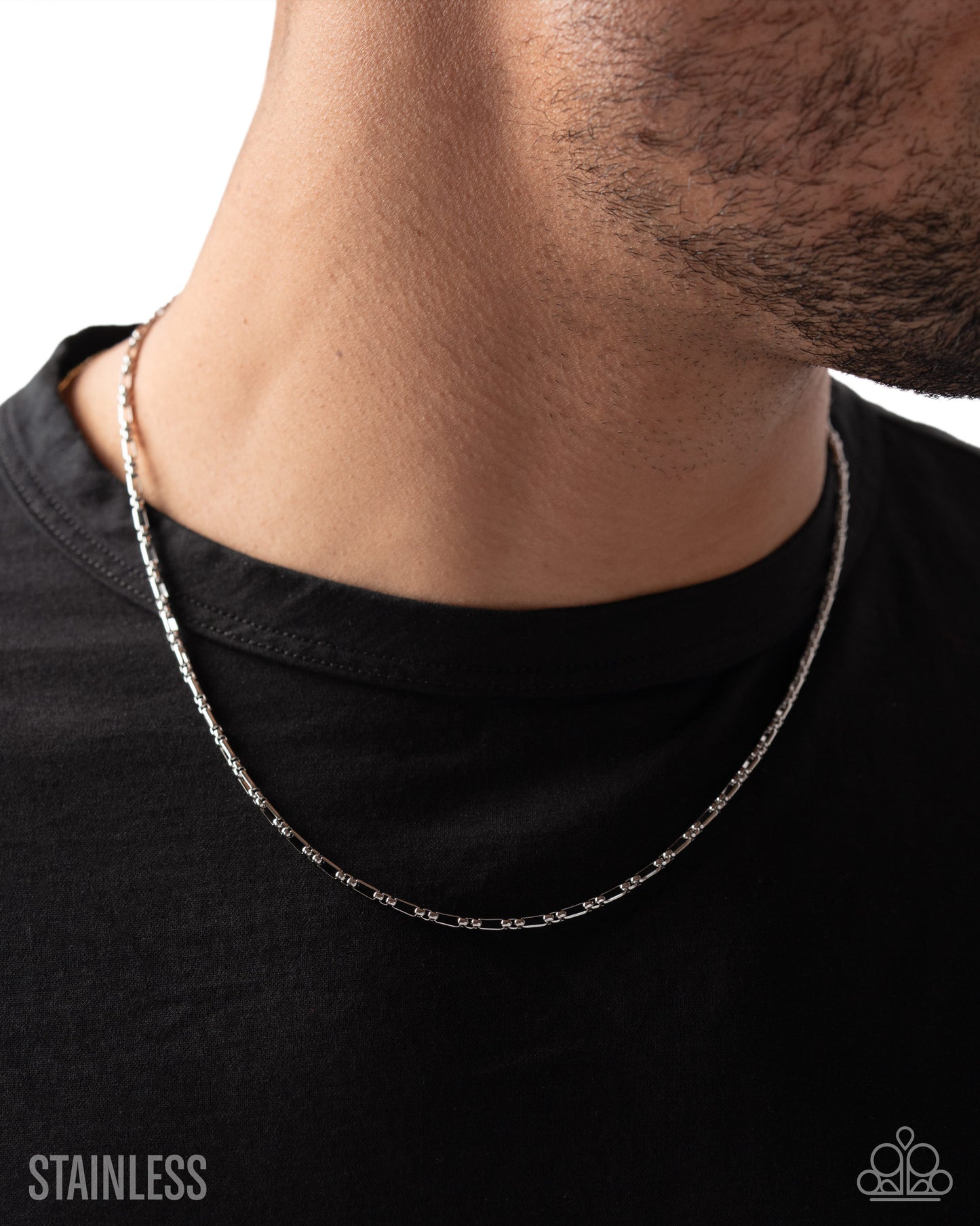 Silver chain necklace worn by a person on a black background with 'Stainless' text.