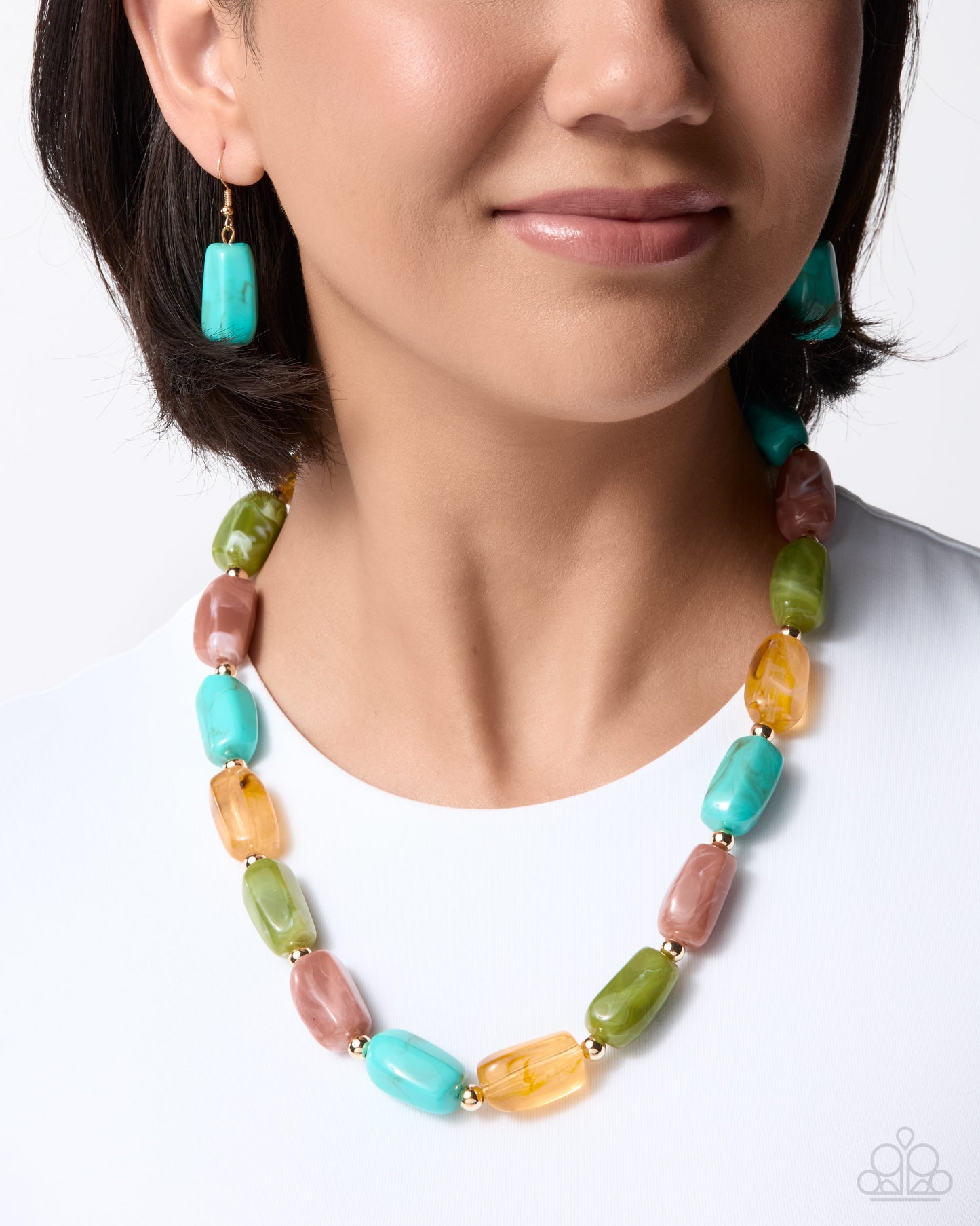 A close-up of a model wearing a colorful beaded necklace and matching drop earrings. The jewelry features chunky, elongated rectangular beads in turquoise, green, peach, and orange with gold-tone spacers, set against a clean white background.