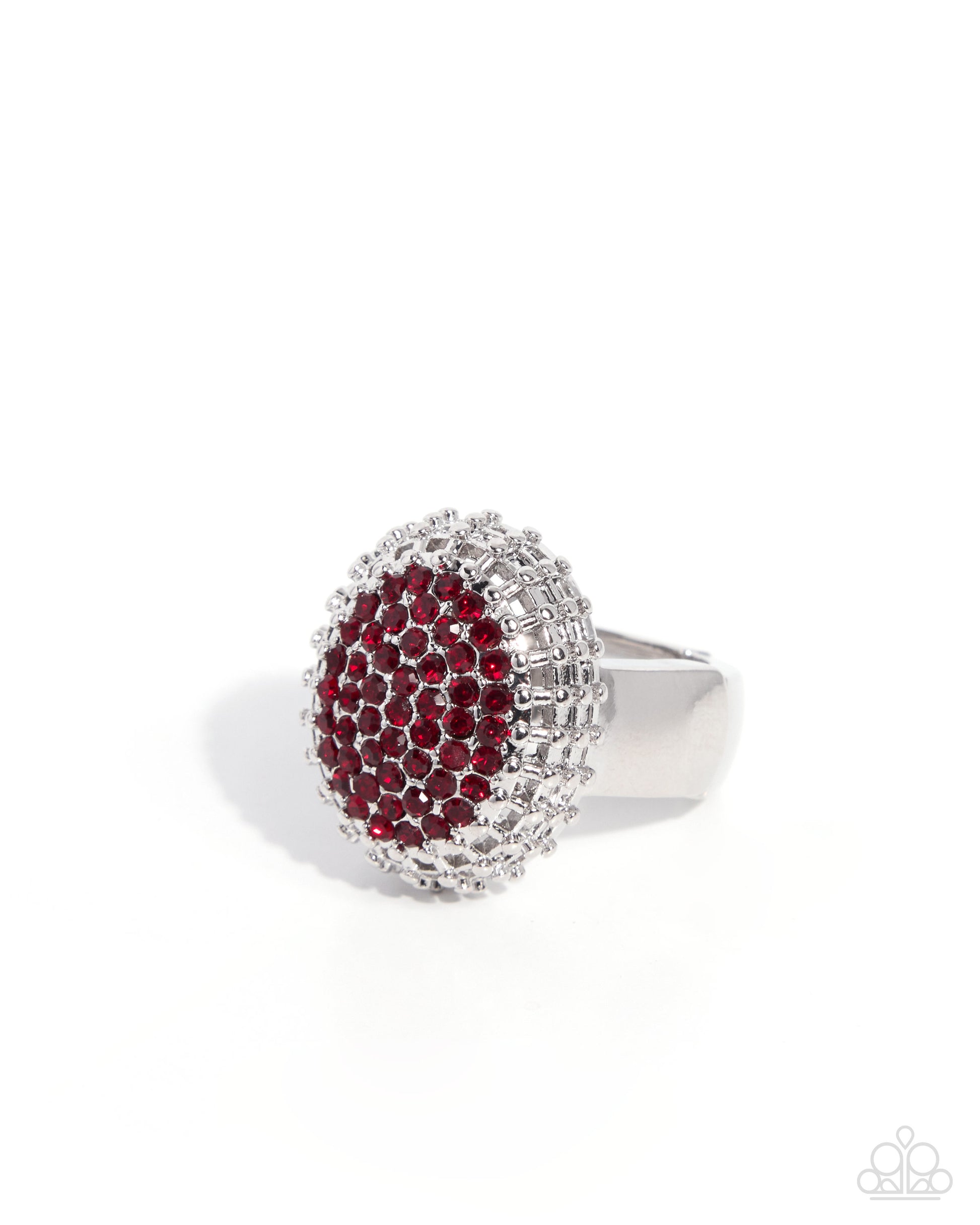 A silver-toned ring featuring a large oval face paved with deep red gemstones, surrounded by a halo of clear stones, set against a plain white background.