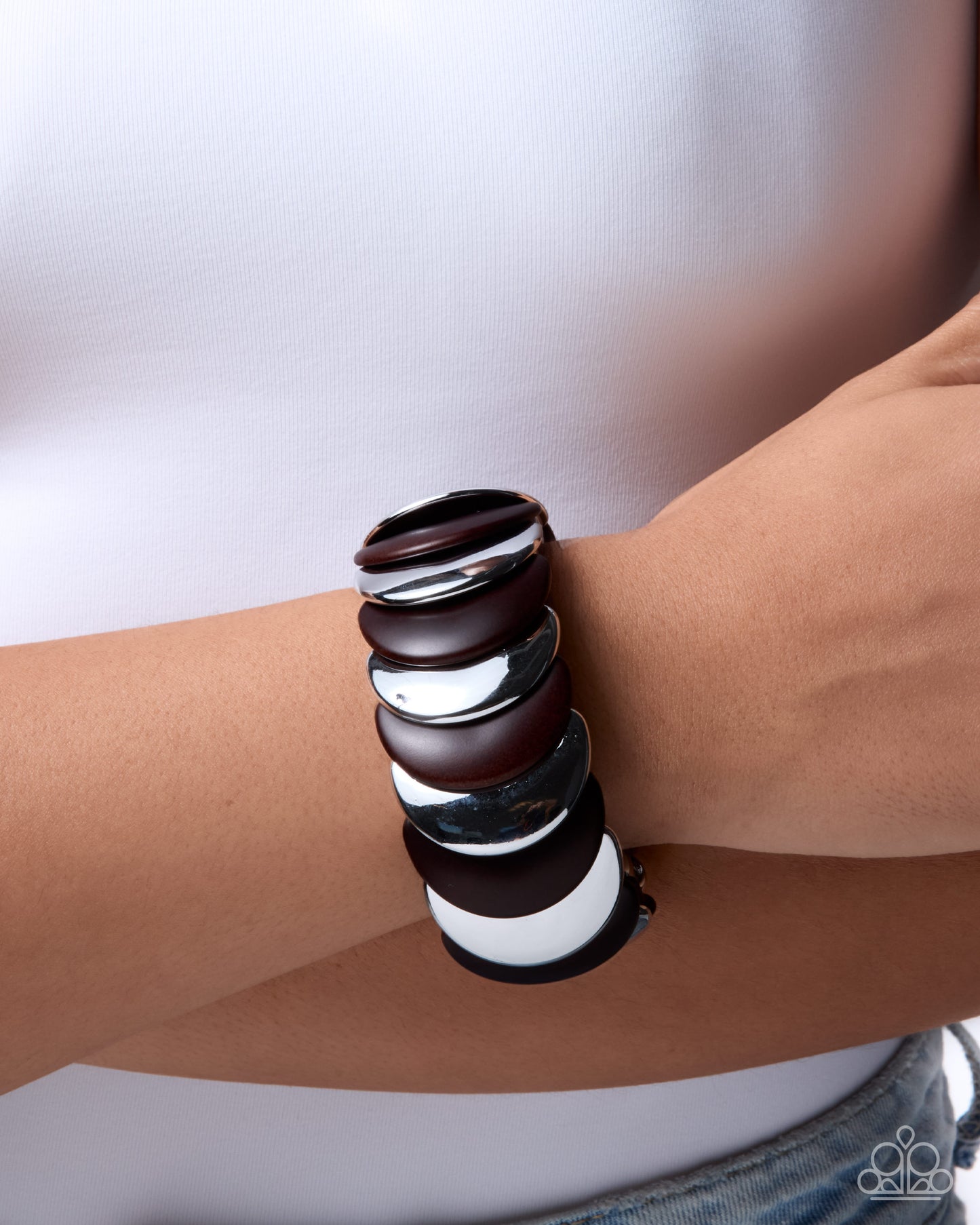 Stacked leather bracelets on a wrist against a neutral background