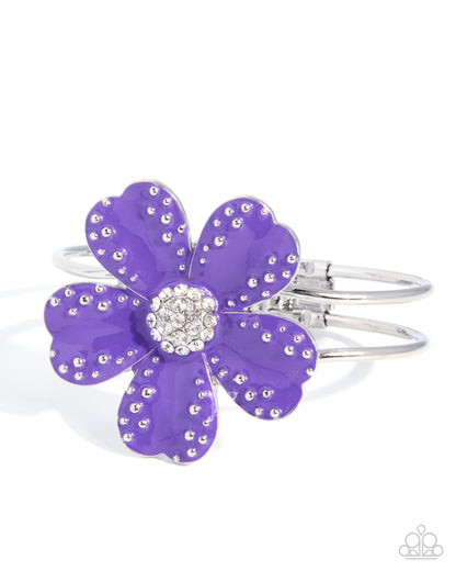A silver-tone flower-shaped cuff bracelet with vibrant purple enamel petals, embellished with small clear rhinestones around the petals and a matching rhinestone center, shown on a white background.