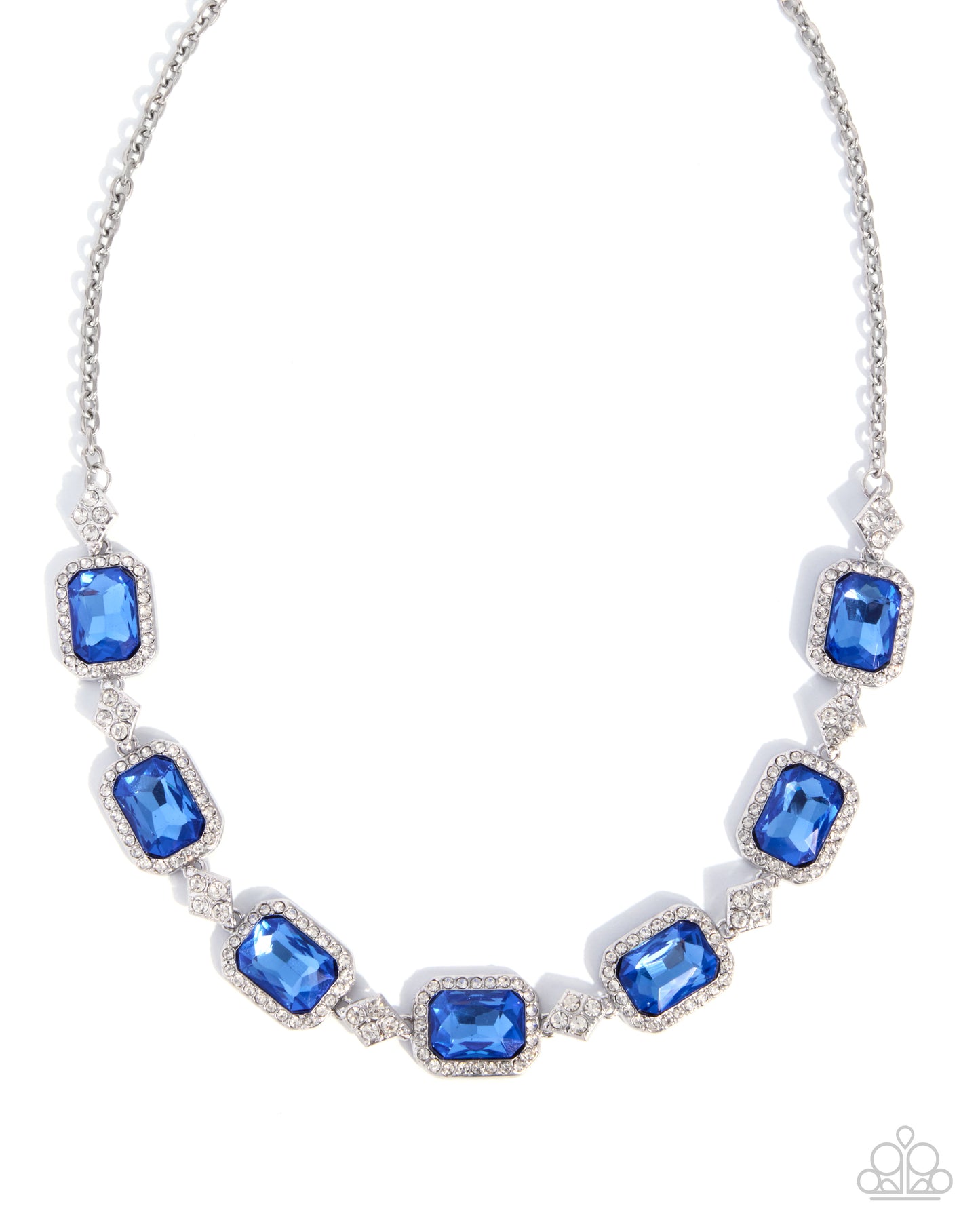 A silver-toned statement necklace featuring seven rectangular emerald-cut blue crystals in a halo setting, separated by small clear crystals, on a white background.