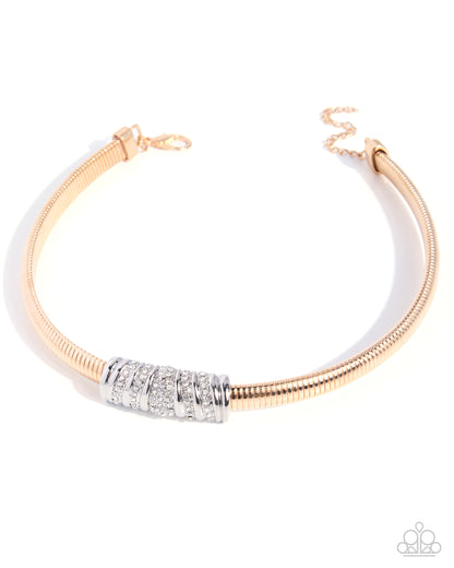 A rose gold snake chain bracelet with a central silver-toned cylinder set with clear pavé stones, shown on a white background with a soft shadow.