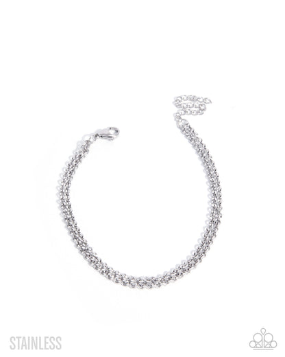 A silver stainless steel chain bracelet with a lobster clasp, displayed on a clean white background with 'STAINLESS' text in the bottom left and a small logo in the bottom right.