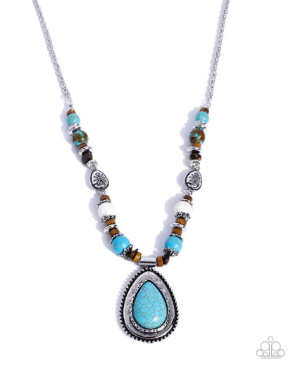 A silver-toned beaded necklace featuring a large teardrop-shaped turquoise pendant, accented with round turquoise beads, brown tiger's eye beads, and white spacer beads on a white background.