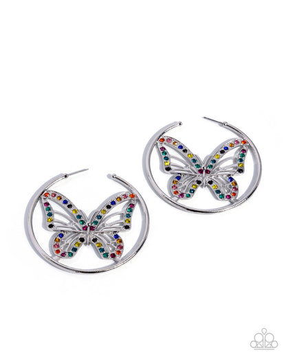 A pair of silver-tone hoop earrings featuring a butterfly design embellished with multicolored rhinestones, shown on a plain white background.