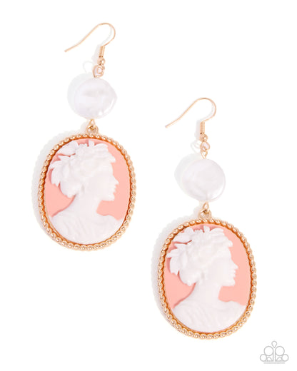 A pair of dangle earrings featuring oval white cameo-style profiles set in a peach-pink background, framed by gold-toned rope borders, with a small round white bead below each pendant. Photographed on a clean white background.