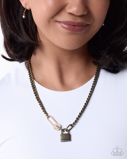 Close-up of brass and gold-tone lock pendants with rhinestones