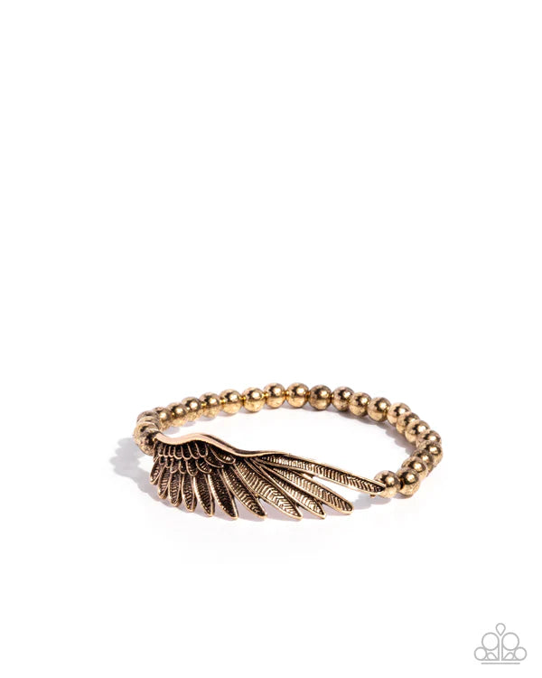 Gold ring with wing design on a white background
