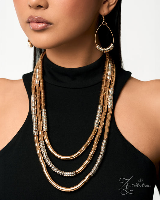 A close-up of a model wearing a multi-strand statement necklace in textured gold and silver, paired with a black turtleneck top and a matching teardrop earring.