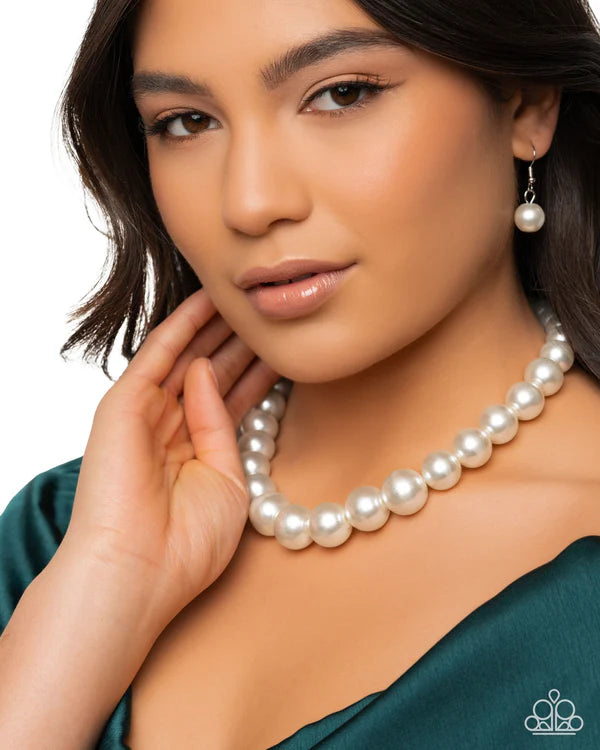 Woman wearing a pearl necklace and earrings on a white background