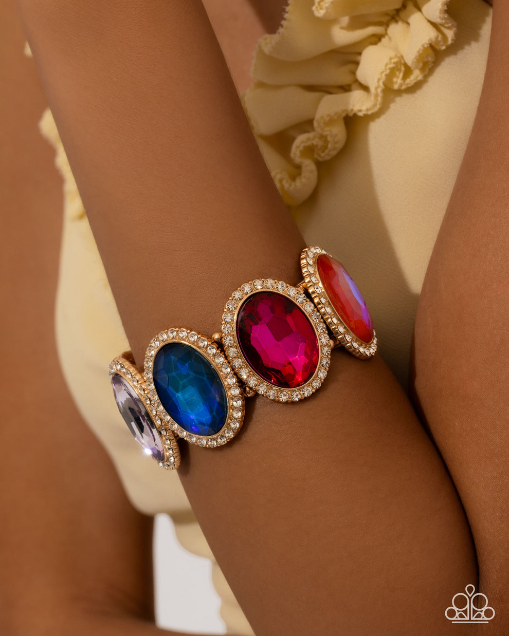 Multicolored gemstone bracelet on a wrist with a neutral background