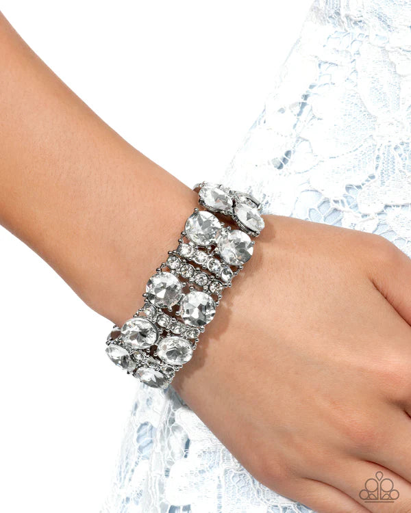 Silver bracelet on a hand with a white background