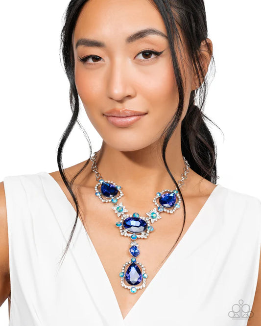Woman wearing a blue gemstone necklace and earrings on a white background