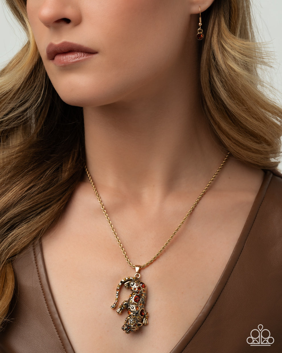 Close-up of a woman wearing a gold necklace with a detailed pendant.