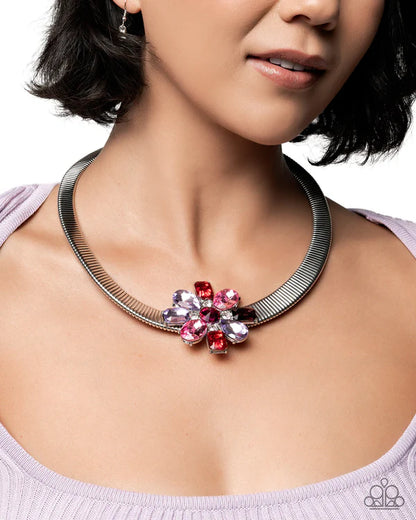 Necklace with a floral pendant featuring pink and red gemstones worn by a model.