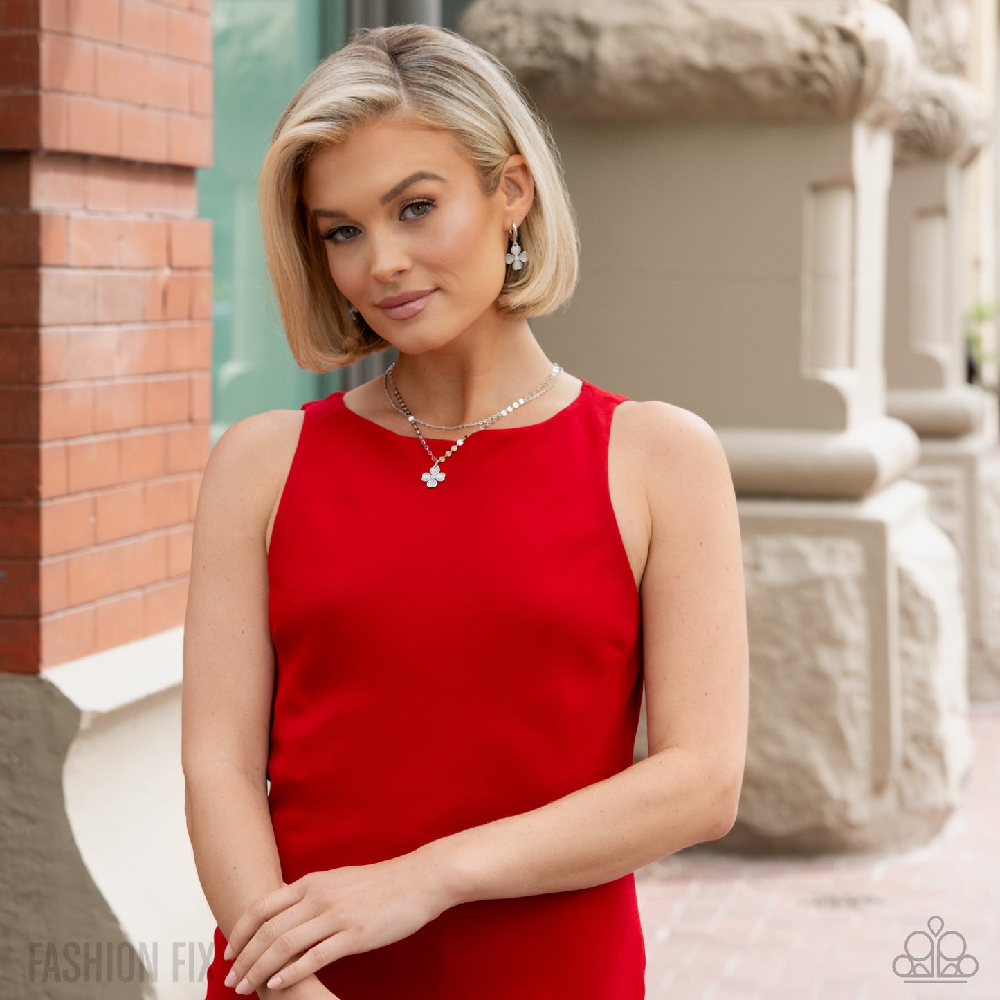 Woman in a red dress standing outdoors with a blurred background