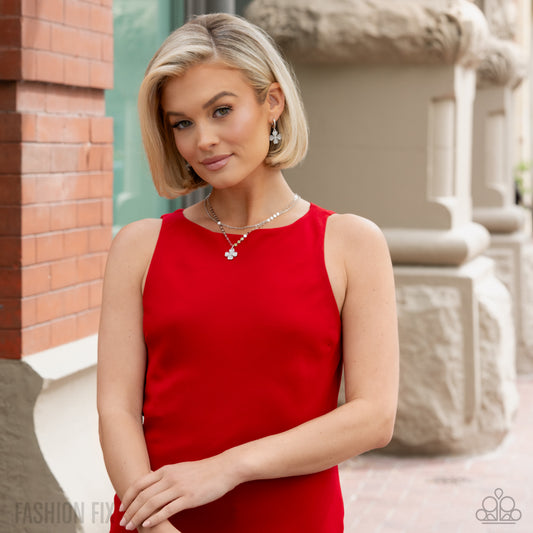 Woman in a red dress standing outdoors with a blurred background