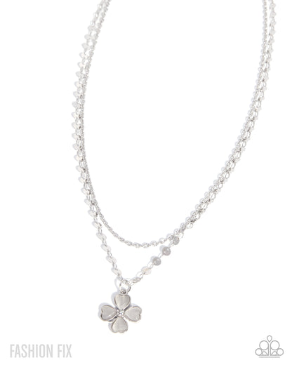 Silver necklace with a flower pendant on a white background